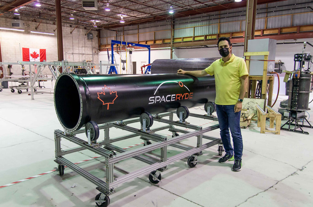 Sohrab standing next to a component of the Ryder rocket engine.